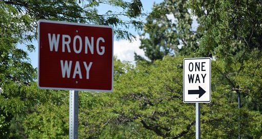 Wrong way sign next to a one way sign